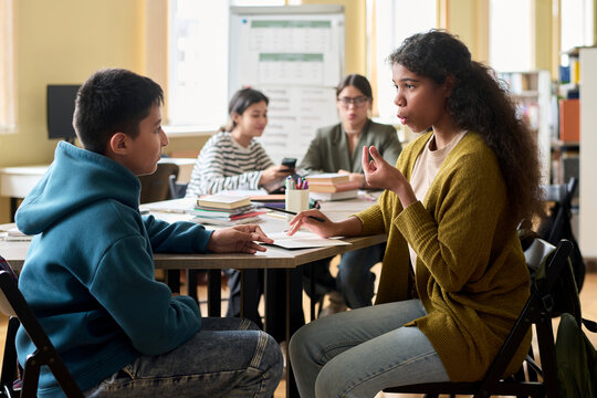 Students practicing pronunciation in pairs during a group class