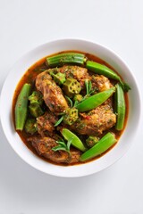 Fototapeta premium Delicious chicken and okra stew served in a white bowl with a rich, spiced sauce
