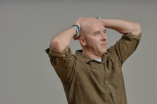 Confident bald man in studio celebrating cancer remission