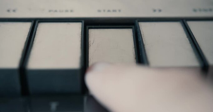 Pushing the start button on a vintage tape recorder