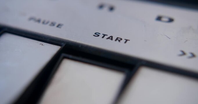  Pushing the start button of a vintage tape recorder