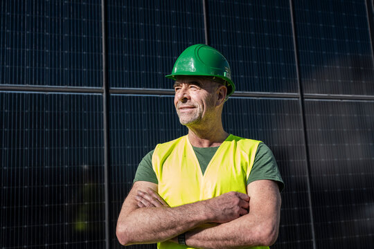 Worker in safety vest and hardhat at solar panel construction site