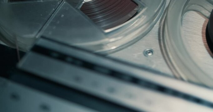 Close-up of a vintage tape recorder playing an old tape in dim light noir style