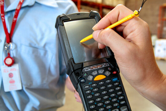 Worker Using Handheld Barcode Scanner Device in Industrial or Retail Setting