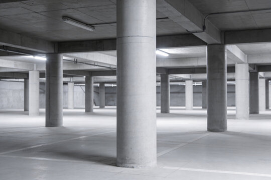 Vast concrete parking garage interior with rows of columns and overhead lighting