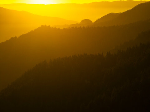 Landscape, tourism: Silhouetted mountain ridges recede into the distance at sunset, creating a sense of depth and tranquility.