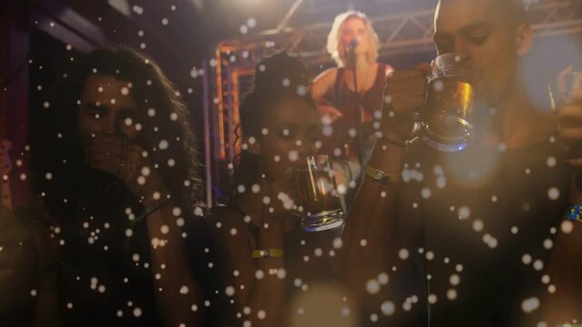 Singer opening chorus at gig causing group lifting mugs and sipping, lights and confetti drifting