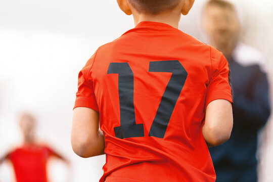 Youth Soccer Player Number 17; Back View of Kid in Red Jersey During Football Match