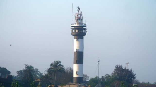 Indian Lighthouse in Moti Daman, a historic active lighthouse with a tall tower near the sea coast, captured in daytime with clear sky
