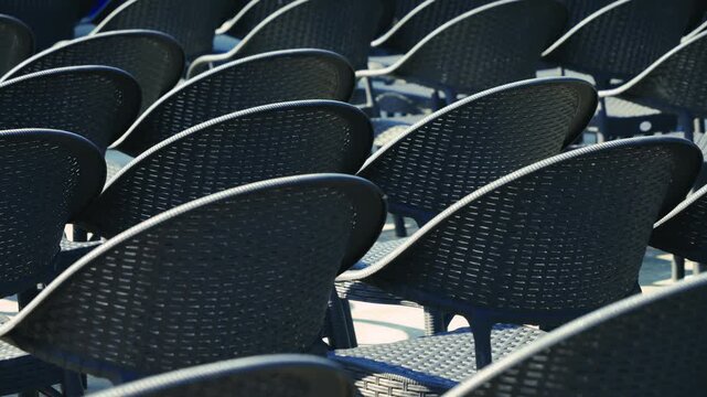 Rows of empty chairs stand in front of the stage before the start of a performance or concert.