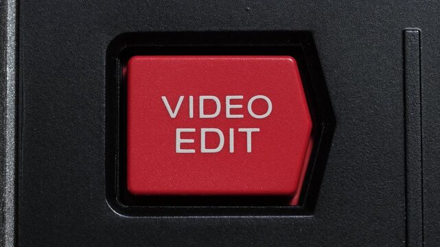 Red video edit button being pressed on black vintage editing controller