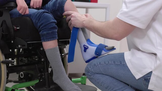 Orthopedist fitting a dafo ankle foot orthosis on a child's leg