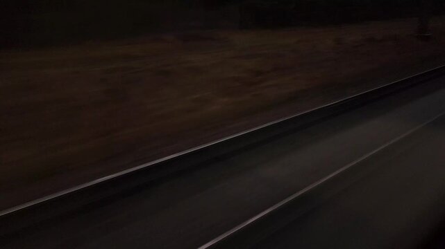 Train rails moving fast during a night journey