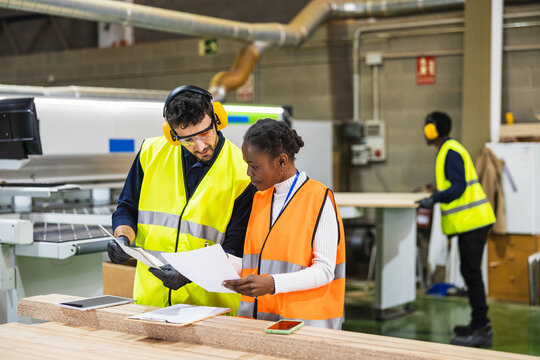 Lumberyard workers reviewing production documents together