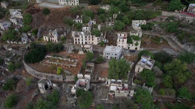 Aerial view flying over the desolate ruins and crumbling houses of Gairo Vecchio, an abandoned ghost town nestled in the Sardinian hills