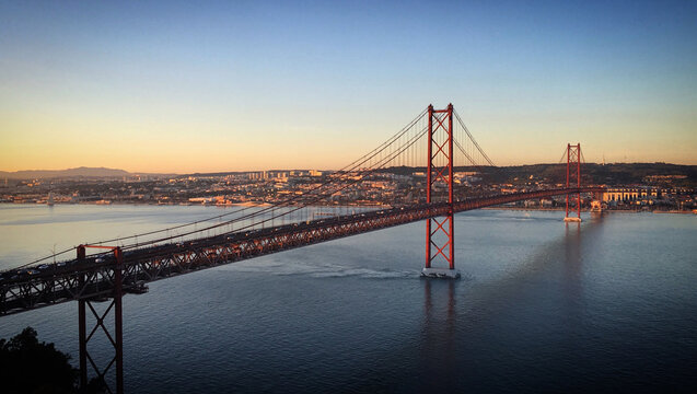 25 de Abril suspension bridge over the water of Tagus river at golden hour, Almada, Lisbon, Portugal, December 2017