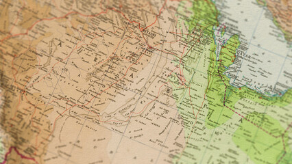 Fototapeta premium Macro close up of a vintage map highlighting Saudi Arabia, showcasing detailed cartography, major regions and cities, and classic antique textures ideal for travel, geography, and historical themes.