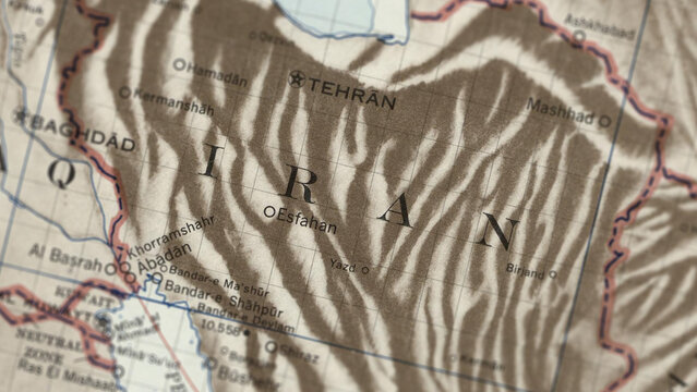 Macro close up of a vintage map highlighting Iran, showcasing detailed cartography, major regions and cities, and classic antique textures ideal for travel, geography, and historical themes.