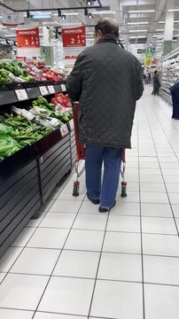 Cliente comprador y consumidor con carro de la compra por pasillo de supermercado con estante, alimentos y oferta