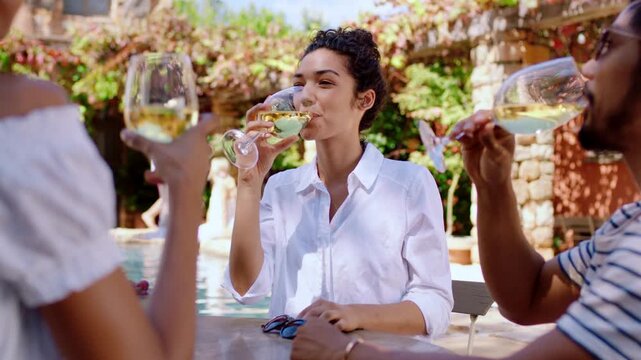 Woman, friends and white wine on holiday at villa for summer reunion, social gathering or relax. Travel, happy people or drinking alcohol at lodge for vacation trip, weekend break or bonding poolside