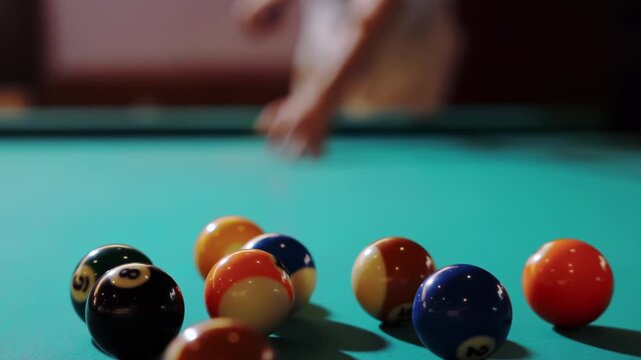 Experience billiard player play with cue aiming at colorful balls opening spread on billiards pool green table, man breaks first shot snooker balls by hitting white ball, sport activity at home indoor