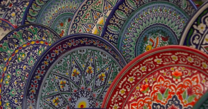 colorful handmade ceramic plates with floral and geometric ornaments traditional decorative pottery market craft and folk art concept Close up handmade ceramics tableware and authentic craft