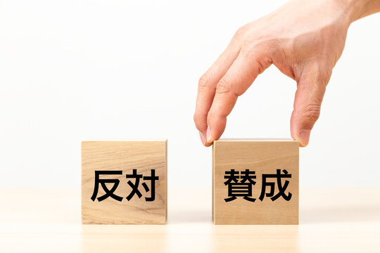 「賛成」と書かれたブロックを選ぶ手元