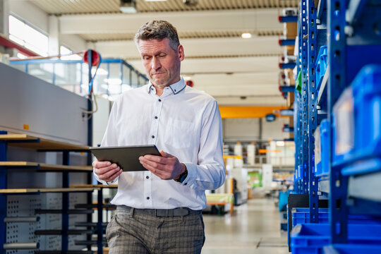 Man with tablet inspecting production hall in industrial business