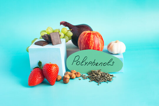 Products containing useful polyphenols in their composition. Grapes, onions, garlic, chocolate and other products in close-up on a light background and the inscription on paper "polyphenols".