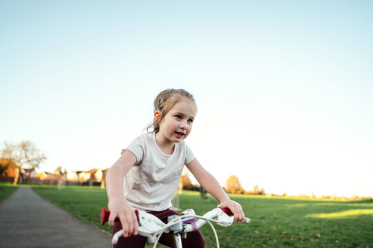 Child riding bicycle in park on a sunny spring day in leisure time