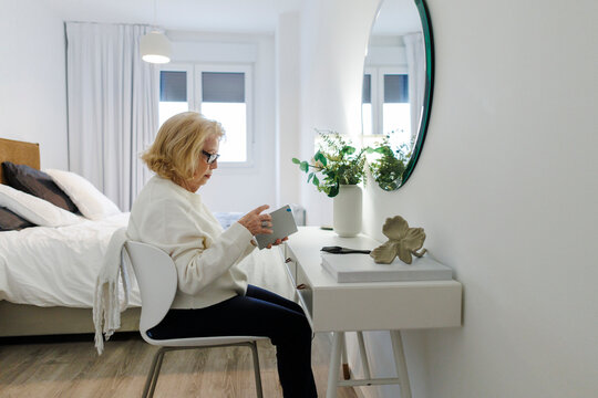 Smiling woman reading indoors at home on a relaxing morning