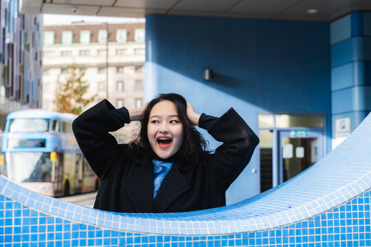 Excited woman expressing joy outdoors in urban city setting