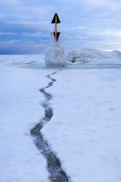 Crack in frozen Baltic Sea with marker post at R�gen Sellin in winter