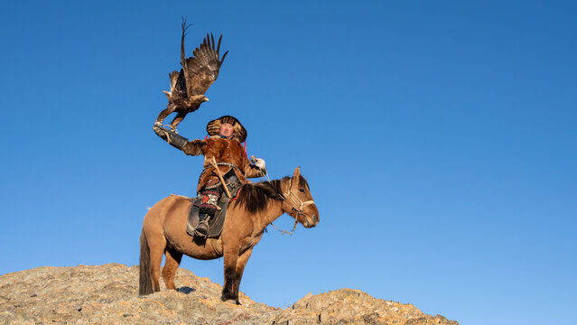 Traditional eagle hunter on horseback in Altai Mountains Mongolia