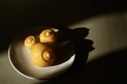 Traditional preserved lemons on a dish in dramatic sunlight