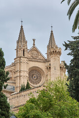 Obraz premium Detailed stone masonry and religious sculptures on the exterior of Palma Cathedral, a premier example of Catalan Gothic architecture in the Balearic Islands.