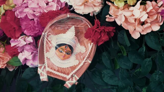 Close up of Durga face decorated ritual items in West Bengal India, showing divine expression and rich cultural aesthetics.