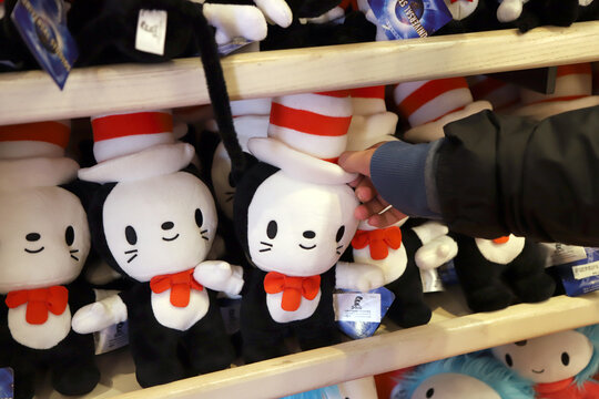 
Child choosing a plush toy from The Cat in the Hat at a themed store