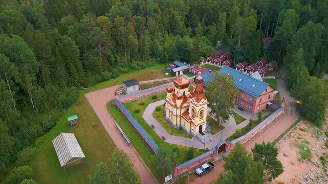 Epic remote coast aerial tilt up. 
Cinematic 4K drone pull-away flight 
from historic church to majestic isolated 
island forest landscape and deep lake.
