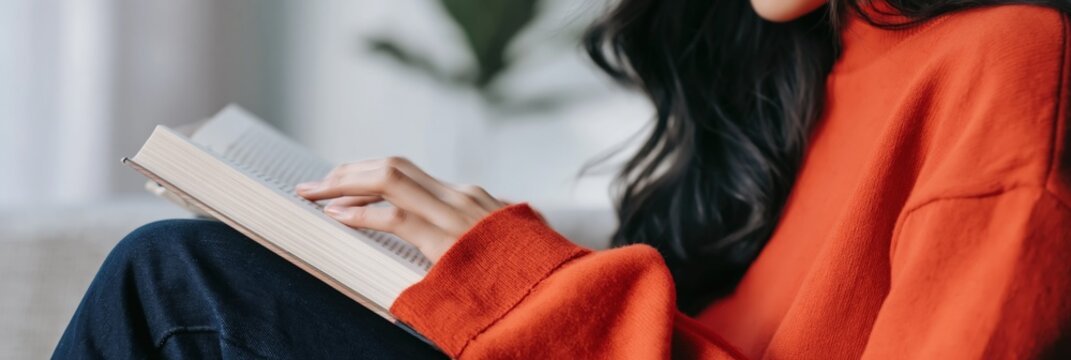 Female reader turning pages while relaxing on sofa