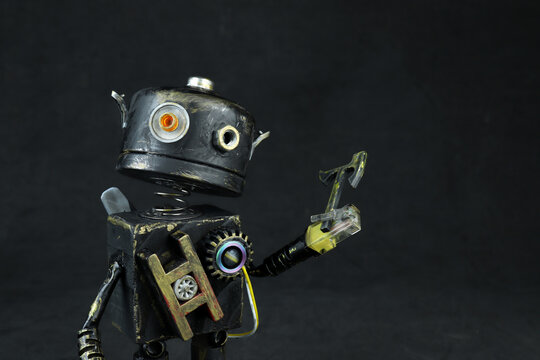 creative robot diy craft from recycled trash materials hands painting small handmade robot model on workbench concept of reuse recycling and DIY creativity with mechanical parts and artistic design