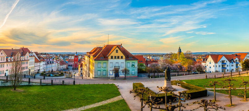 Panoramic view over Gotha city center with historic buildings, market square and monument, colorful rooftops and wide green foreground under soft evening sky in Thuringia, Germany