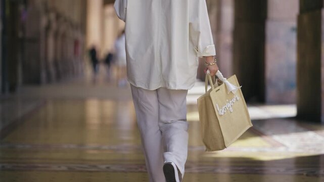Woman with Shopping Bag Walking in Elegant Italian City Gallery