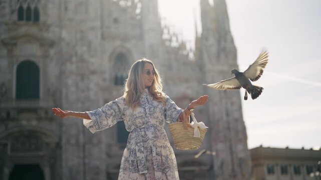 Sunrise Serenity: Woman Feeding Pigeons at Milan Duomo Square
