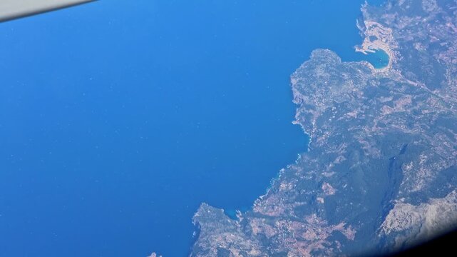 Aerial view of Serra de Tramuntana mountains and Port de Soller coast in Mallorca Spain from airplane window