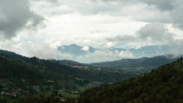 4K Cinematic mountain valley time-lapse with rolling clouds over green hills in Himachal Pradesh, India.