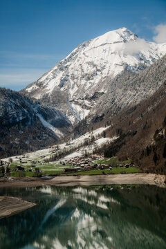 View of snow-capped mountain reflecting serenely in the lake's calm waters, a picturesque scene of nature's grandeur, Train from Lucerne to Interlaken, Switzerland.