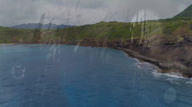 Camera panning over coastal bay through wet glass, aircraft motion revealing shoreline for travel