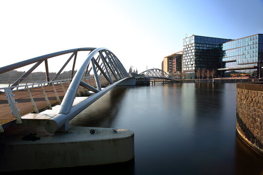 Moderm architecture in the Oosterdok district in Amsterdam, Netherlands, with a moderm bridge called Veldebrug, modern buildings and the basilica of St Nicholas in the background