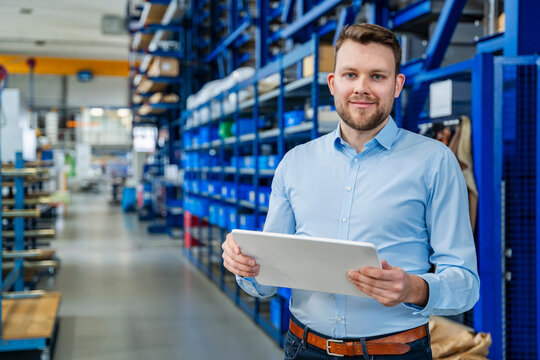 Employee with tablet in production hall of industrial business